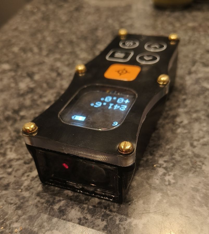 An earlier printed prototype of the DiscoX on a worktop, angled to show the open laser aperture at the front with the red laser visible inside.